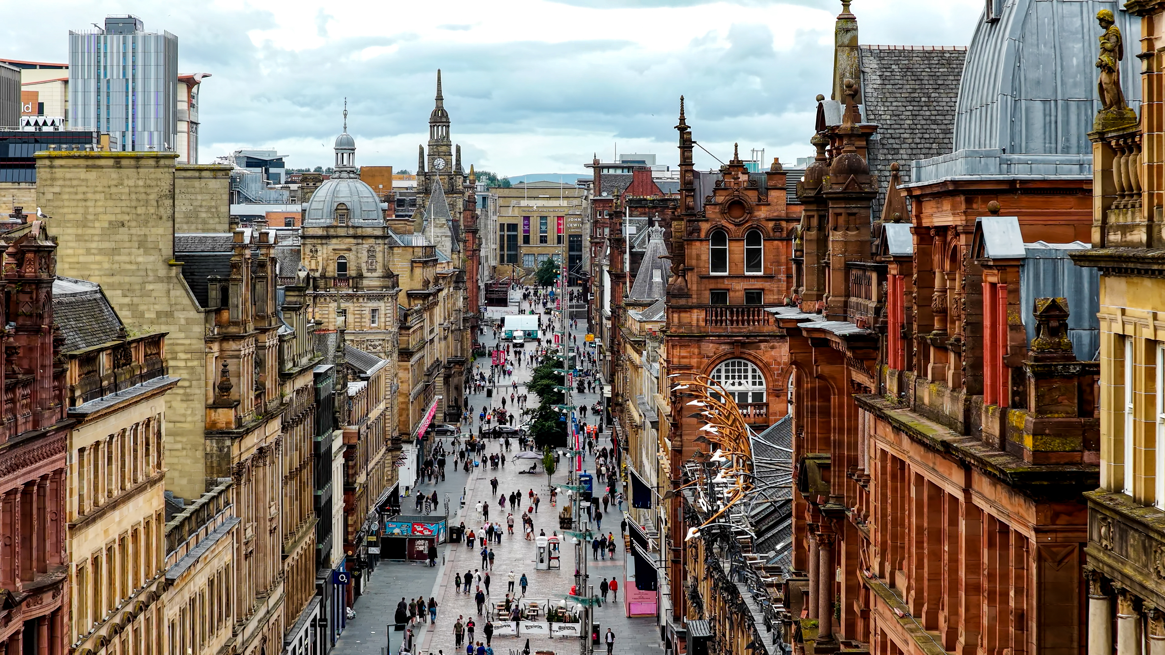 Aerial view of Buchanan Street in Glasgow city center with historic sandstone buildings and pedestrian shopping zone, Busy urban street filled with people and retail stores, Tourism and lifestyle concept for travel design